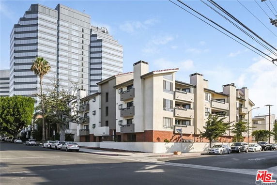 Front view of a multi-story apartment building with balconies.