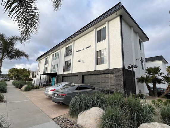 Front view of a multi-story building with a garage.