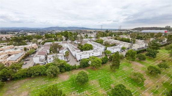 Aerial view of apartment buildings surrounded by greenery and trees.