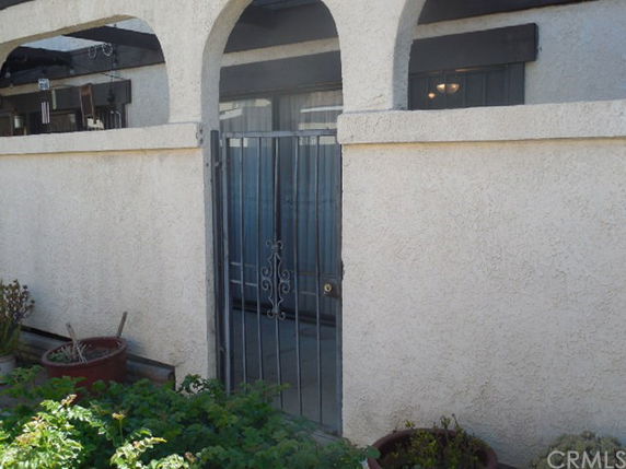Front view of a building entrance with an arched design and metal gate.