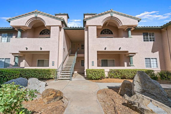 Front view of a two-story apartment building with outdoor stairs.