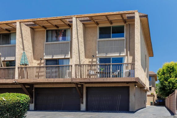 Front view of a two-story building with a balcony and garage.