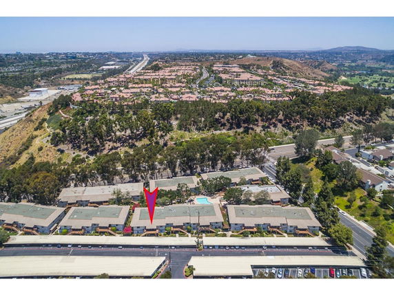 Aerial view of residential area with multiple buildings and nearby roads.