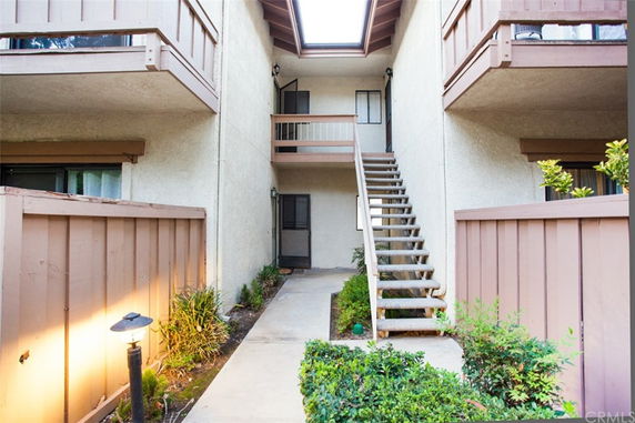 View of a two-story building with exterior staircase and balcony.