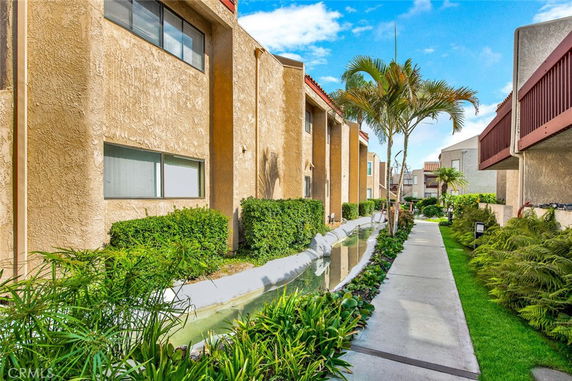 Front view of a residential building complex with pathway and landscaping.