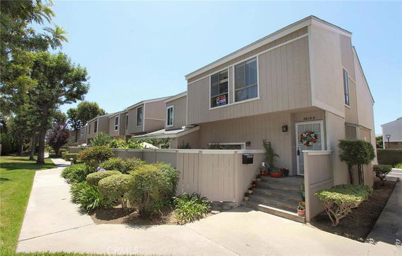 Front view of a two-story townhouse with stairs leading to the entrance.