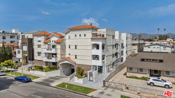 Front view of a multi-story apartment building with balconies.