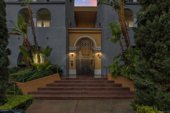 Front view of a multi-story building with an ornate entrance and steps.