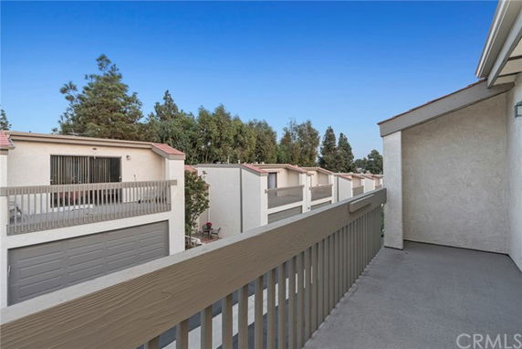 Balcony view overlooking a row of townhouses with garages.