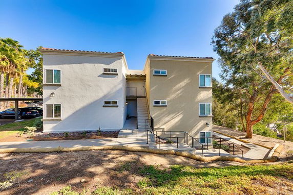 Front view of a two-story apartment building with multiple windows.