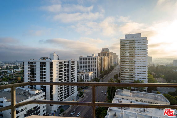 Panoramic view from a high floor overlooking city buildings and streets.