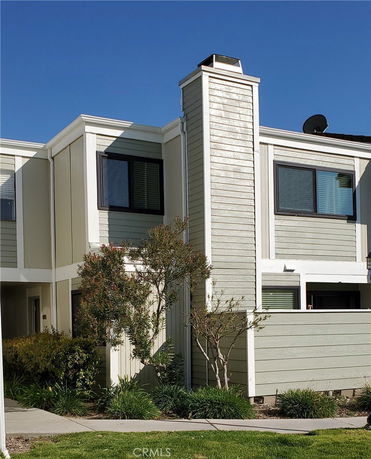 Front view of a modern two-story townhouse with a chimney and large windows.