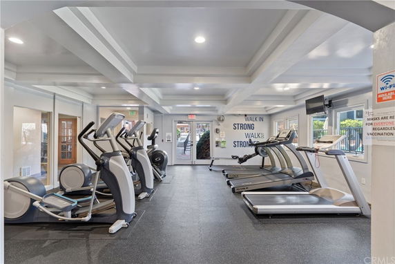 Interior view of a gym with exercise equipment such as treadmills and elliptical machines.