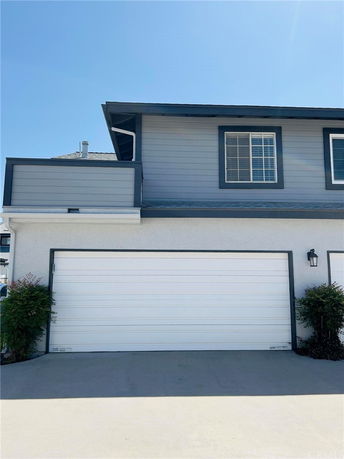 Front view of a house with a two-car garage and upper floor window.
