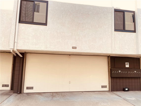 Front view of a building with a garage door and windows.