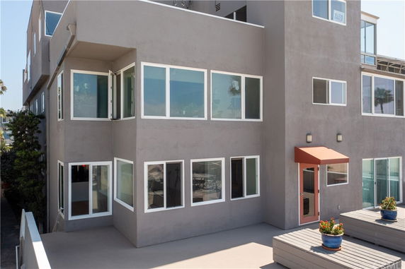 Front view of a multi-story building with large windows and a small entrance canopy.