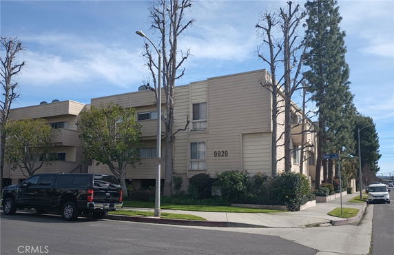 Front view of a multi-story residential building on a street corner.