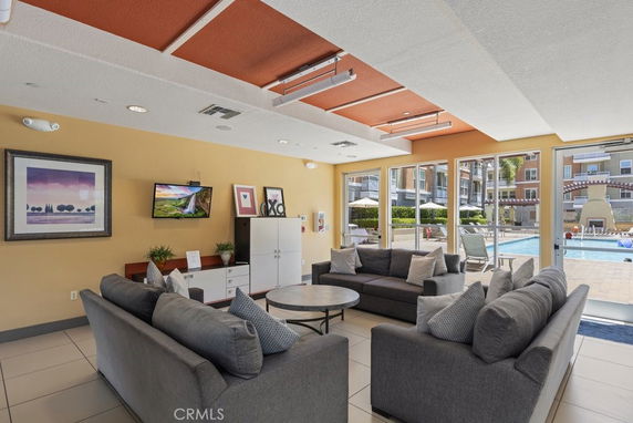 Indoor lounge area with sofas and a view of the outdoor swimming pool.