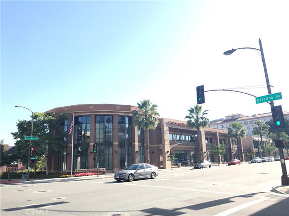 Front view of a modern multi-story commercial building at a street intersection.