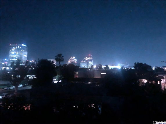 Wide-angle night view of a cityscape with illuminated buildings.