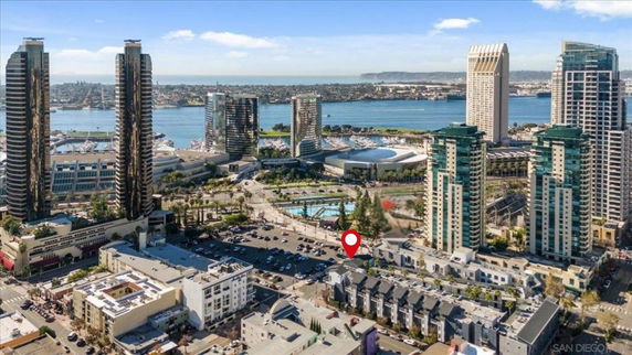 Panoramic view of urban skyline with tall buildings near a waterfront.
