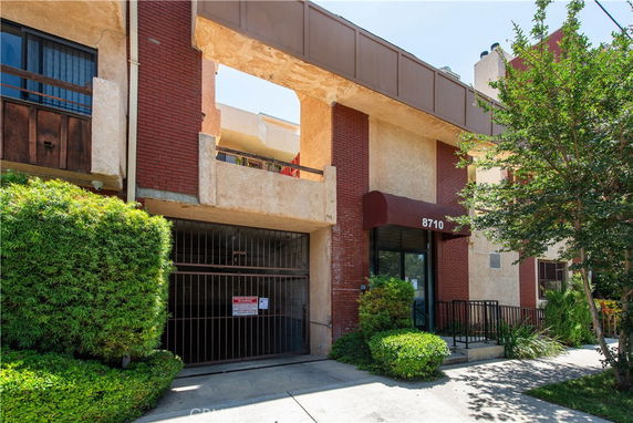 Front view of a multi-story building with brick and stucco facade.