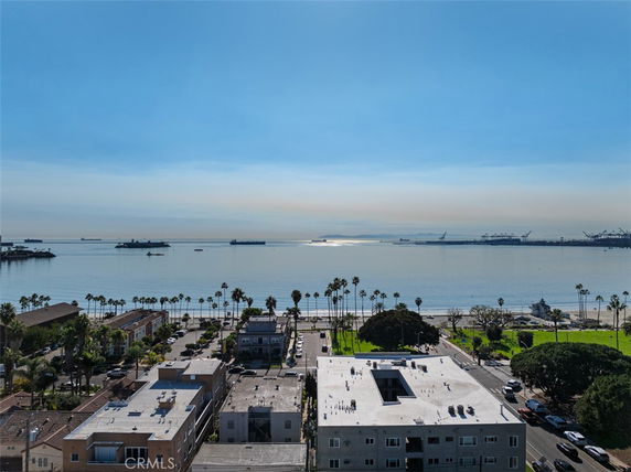 Wide angle view of buildings with a waterfront in the background.