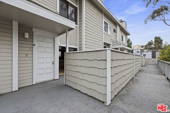 Front view of a multi-story townhouse with an entrance walkway.