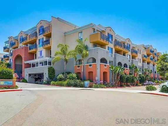 Front view of a multi-story residential building with modern design and balconies.