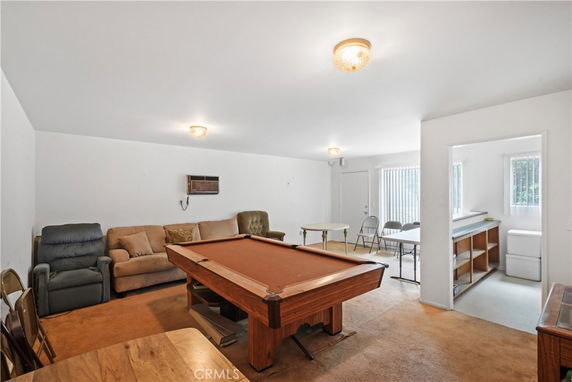 Room with a pool table and seating area