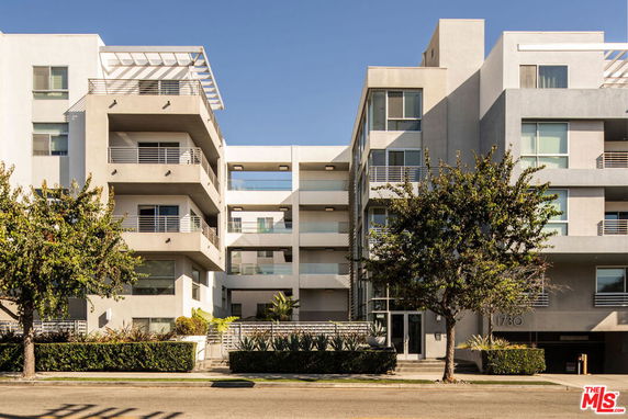Front view of a modern multi-story apartment building with balconies.
