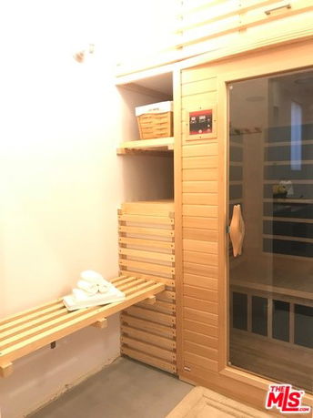 Indoor sauna room with wooden bench and shelves.