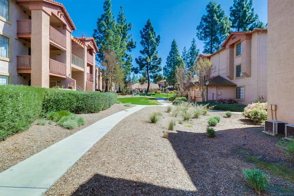 View of apartment buildings with balconies and landscaped paths.