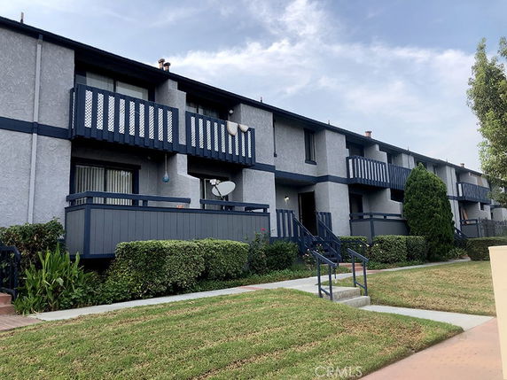 Front view of a multi-story residential building with balconies.