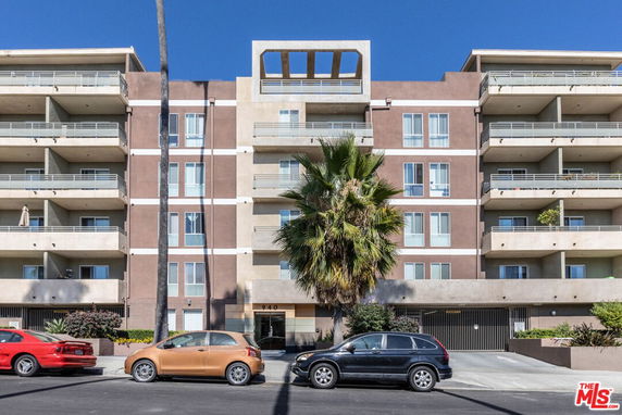 Front view of a multi-story apartment building with balconies.