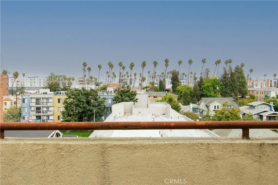 Panoramic view of surrounding residential and commercial buildings with palm trees in the background.