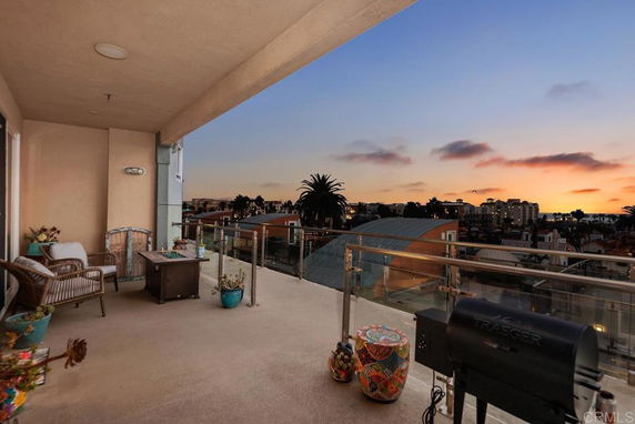 Outdoor balcony view overlooking cityscape with sunset.