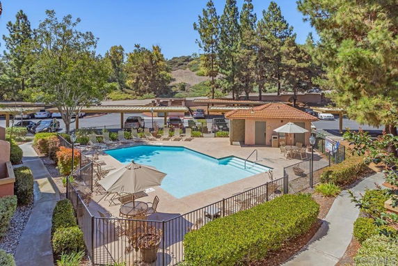 Outdoor swimming pool area with seating and umbrellas.