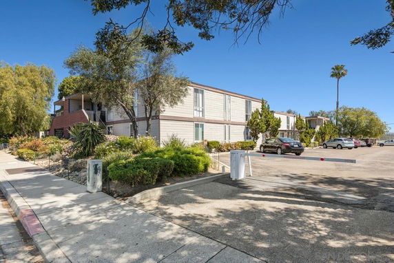 Front view of a two-story apartment building with parking area.