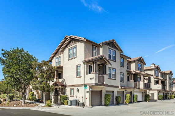 Front view of a multi-story apartment building with garages on the ground level.