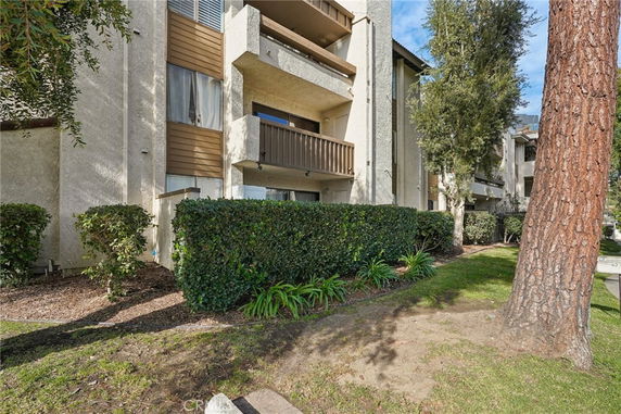 Front view of a multi-story residential building with balconies and a beige exterior.