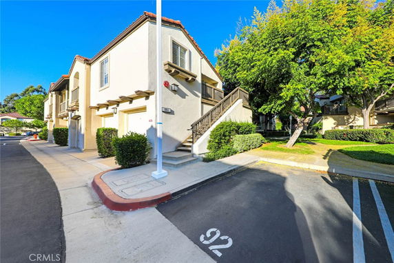 Front view of a multi-story residential building with stairs leading to the upper level.