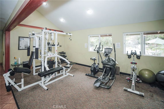 Indoor gym area with exercise equipment including weight machine, treadmill, and stationary bikes.