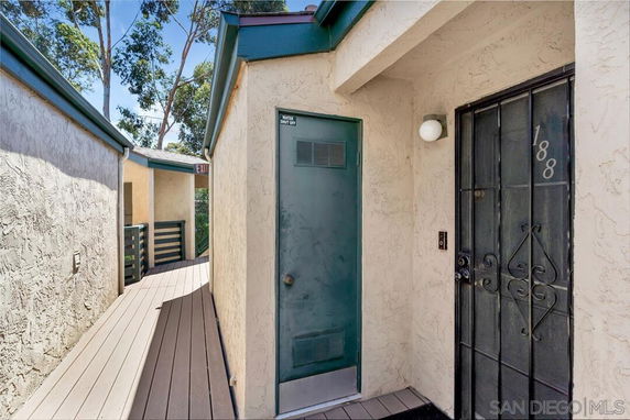 Entrance view of a house with a metal security door and adjacent utility door.