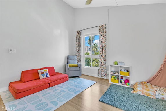 Play area with colorful seating, cushion, and small shelf with toys.