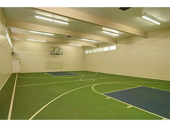 Indoor basketball court with lighting and a hoop.