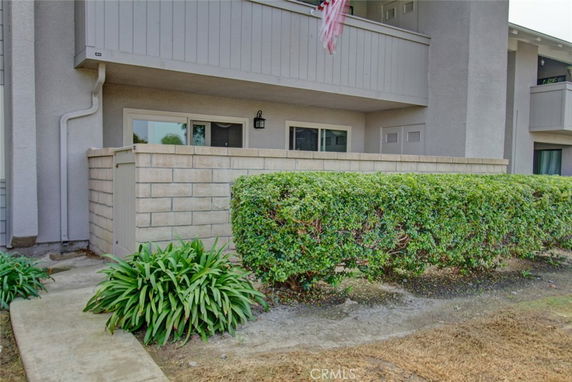 Front view of a building with a small walled patio and balcony.