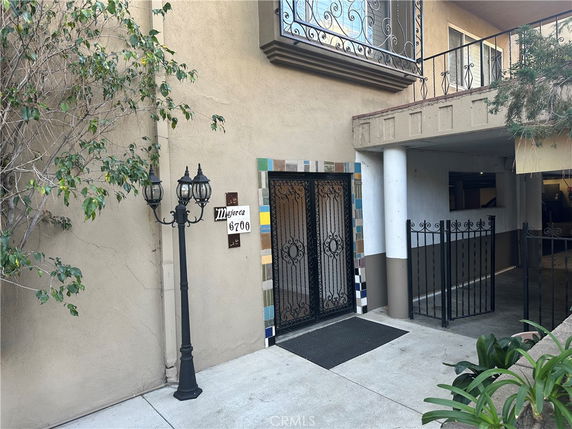 Front view of a building entrance with decorative metal gate and exterior lighting.