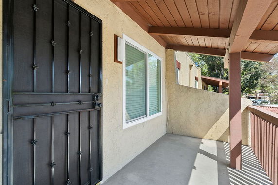 Exterior view of a house with a covered porch and metal front door.