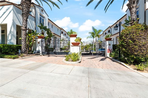 Front view of a row of two-story houses with gated entrance.